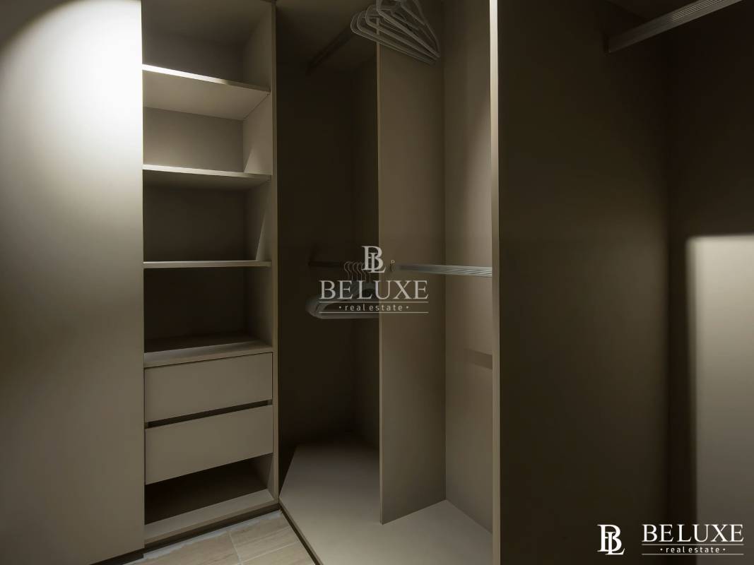 Modern walk-in closet with built-in shelving, drawers and minimalist design in PH Doble Cincuentenario Panama City
