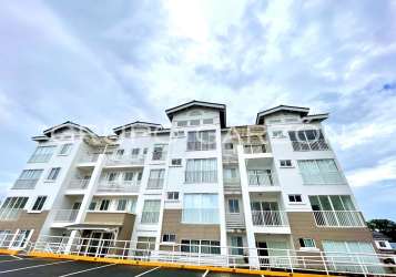 Kitchen with granite countertops, window and white cabinetry in PH Vista Azul Playa Dorada apartment