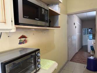 Kitchen with wood cabinets, tile countertops and natural light for house in La Ermita Las Tablas Panama