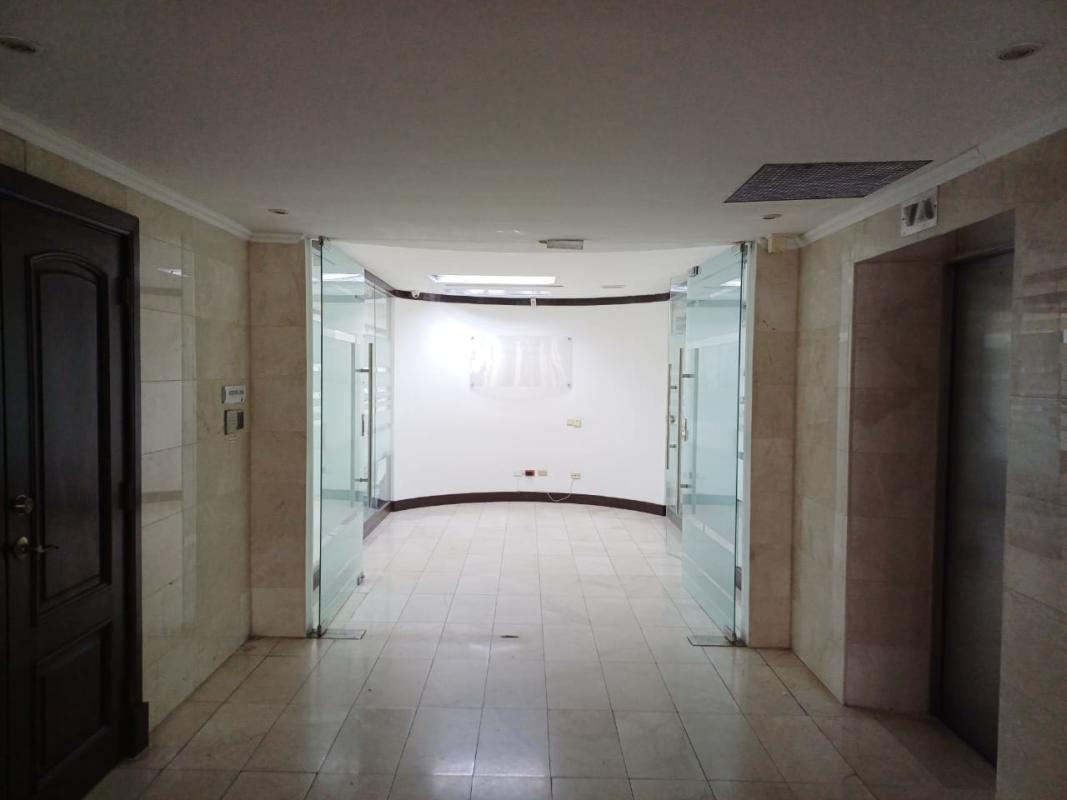 Office room with floor to ceiling windows overlooking Panama City skyline and ocean