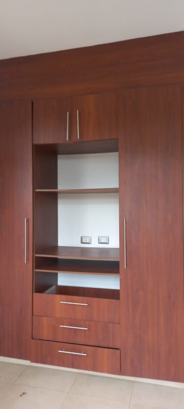 Bedroom with large built-in wooden wardrobe and shelving in Costa Sur Panama