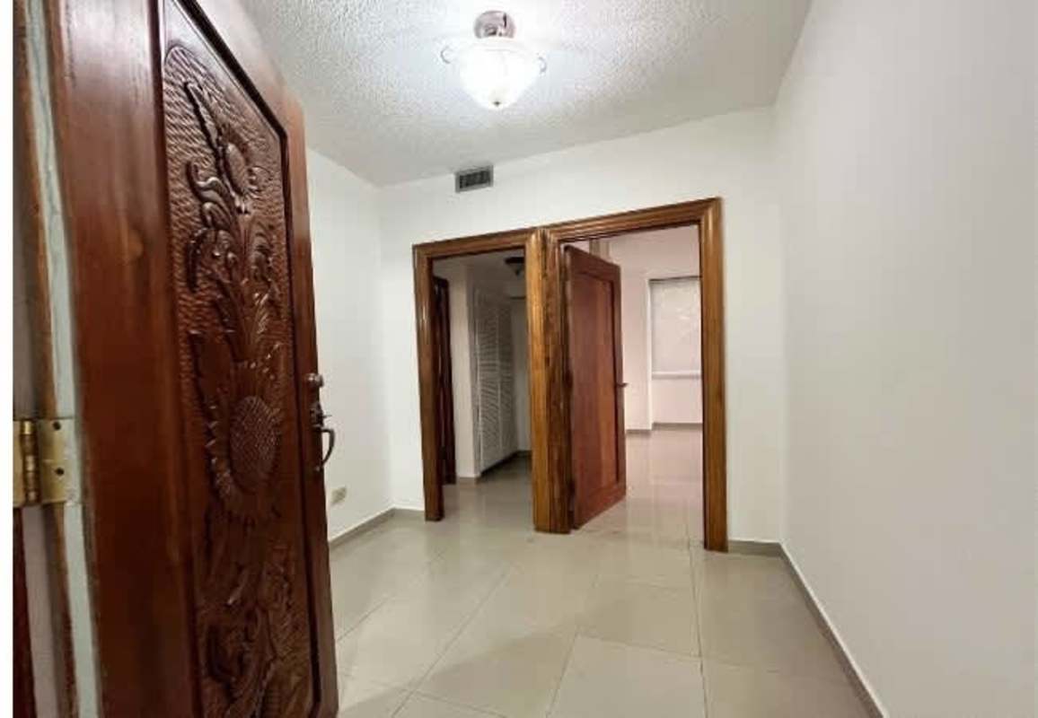 Apartment hallway with native carved wood door at PH Metropolis Panama