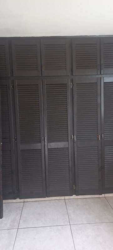 Master bedroom with tiled floor, white walls and ceiling fan in bank-owned house Panama