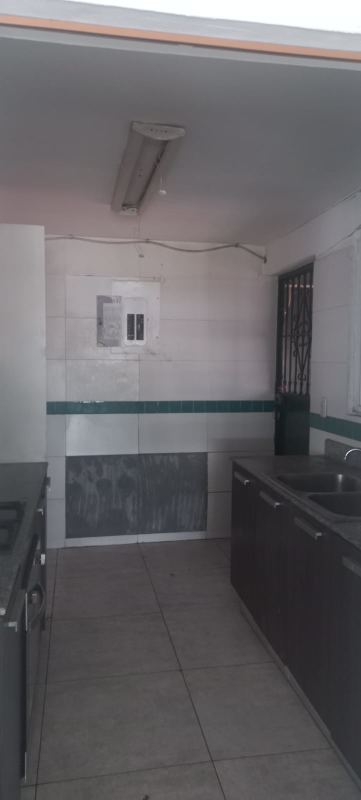 Living area with tiled floor, open entry and white walls bank-owned house Residencial Limajo Panama