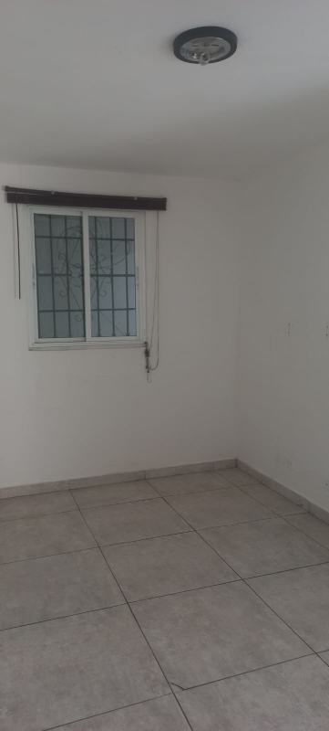 Secure metal gate and covered carport in front of bank-owned house Residencial Limajo Panama