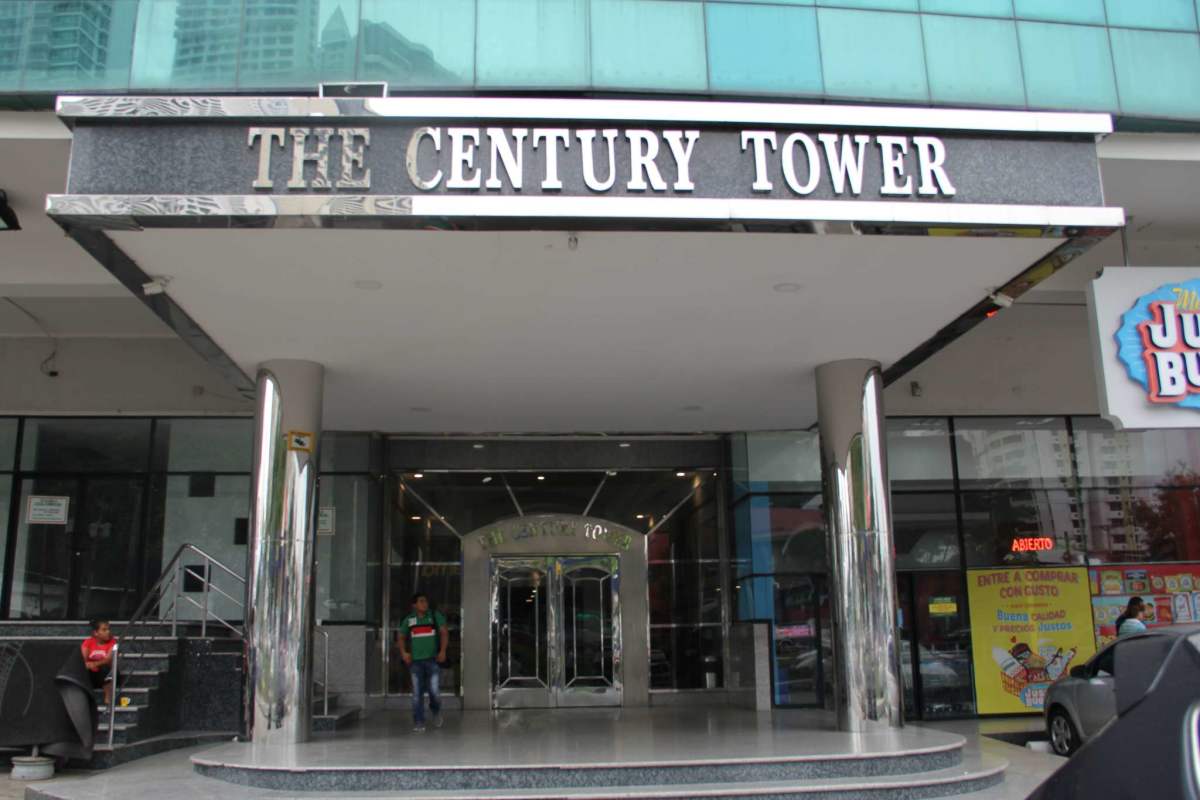 Century Tower entrance with revolving door, glass facade, retail stores in Panama City
