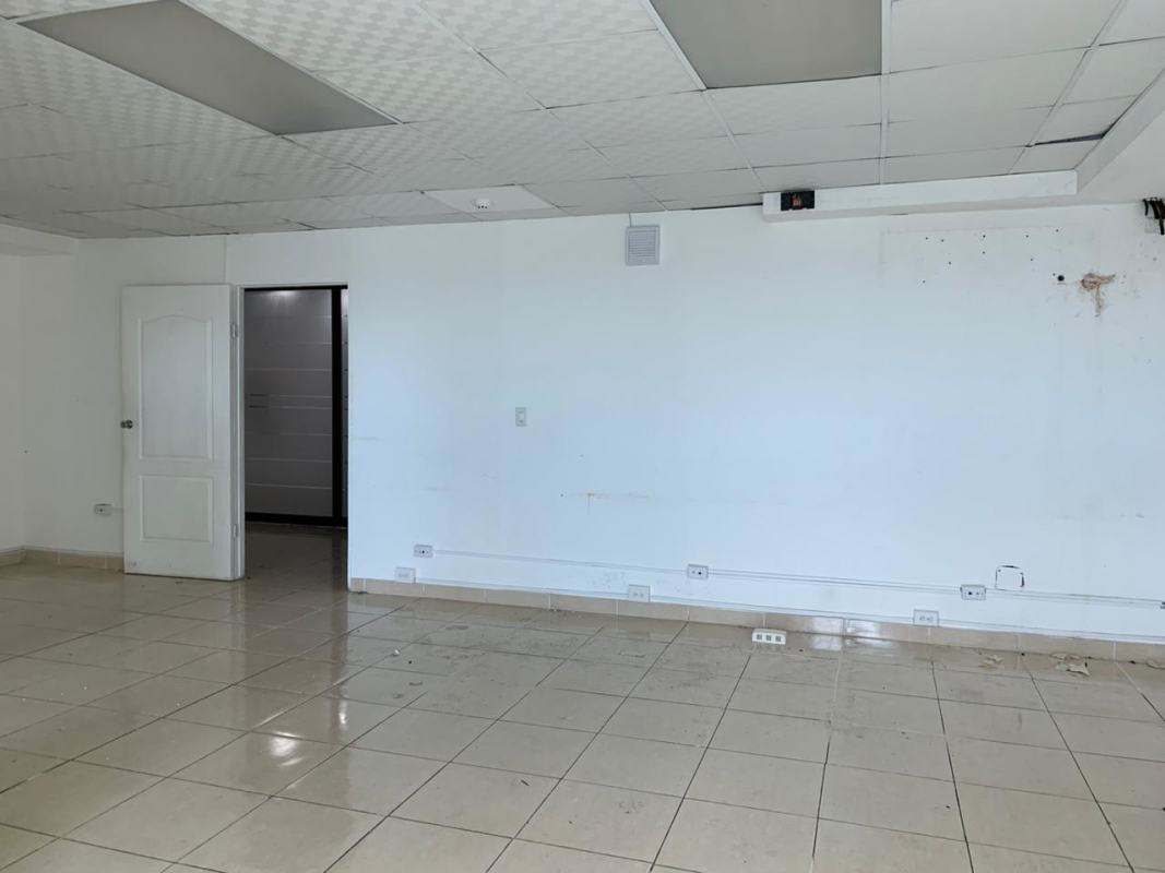 Interior of empty tiled office with drop ceiling and white walls in Century Tower