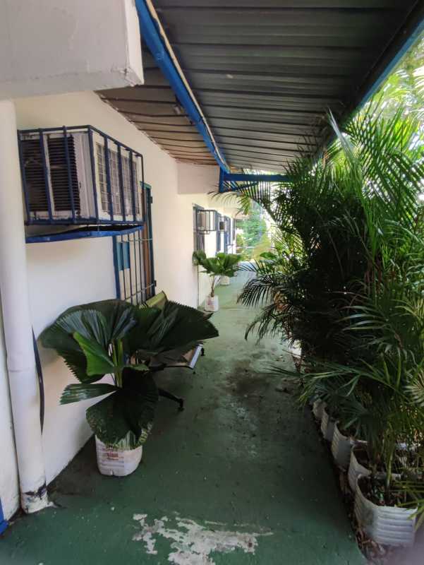 Outdoor corridor with potted plants, barred windows, metal roof in commercial property for sale Panama City