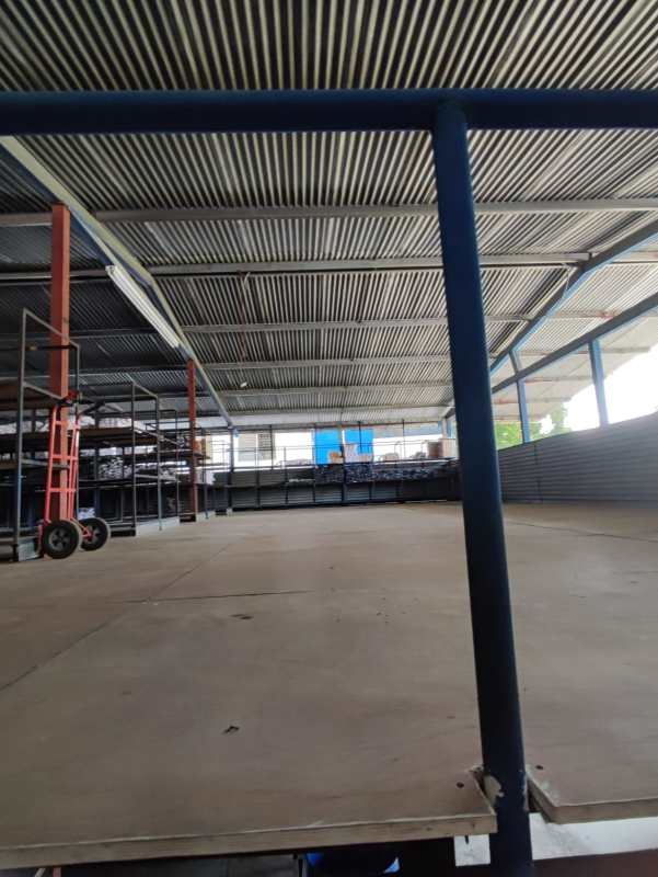 Bright spacious warehouse interior corrugated metal roof shelving units commercial storage Panama City
