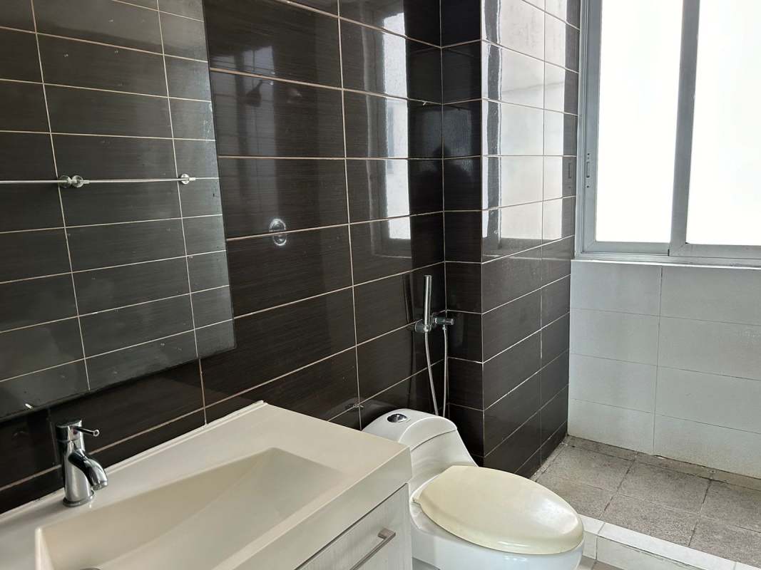 Bathroom with dark tiles, frosted window, sink, toilet in PH Miró apartment