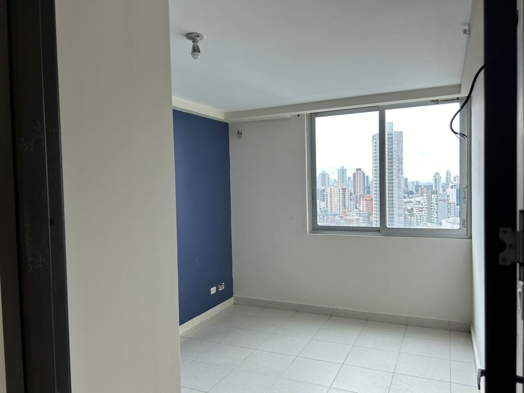 Bedroom with blue accent wall, large window and skyline view PH Miró El Cangrejo