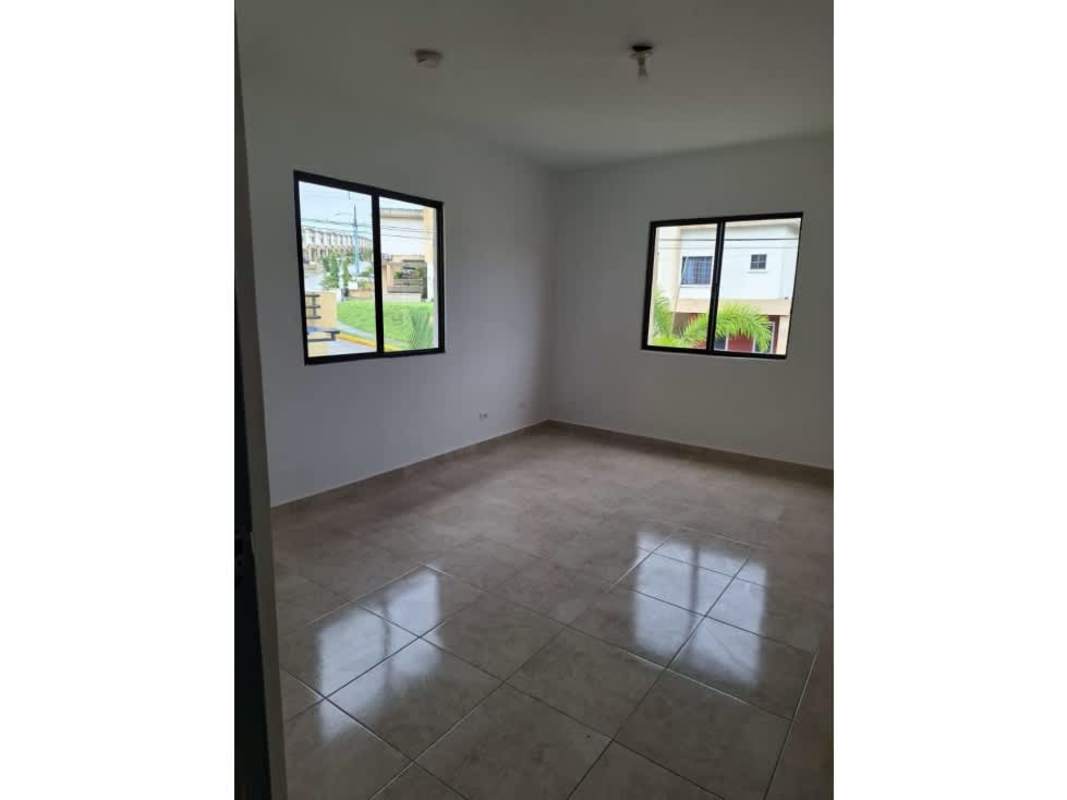 Bedroom with large windows offering views of residential neighborhood in Las Cumbres Panama City