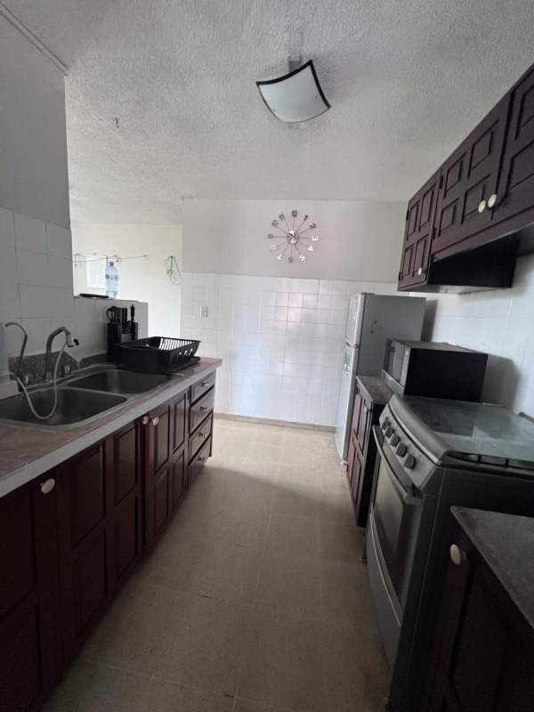 Classic kitchen with cabinets, gas stove, refrigerator and microwave in PH Bella Vista Tower Panama