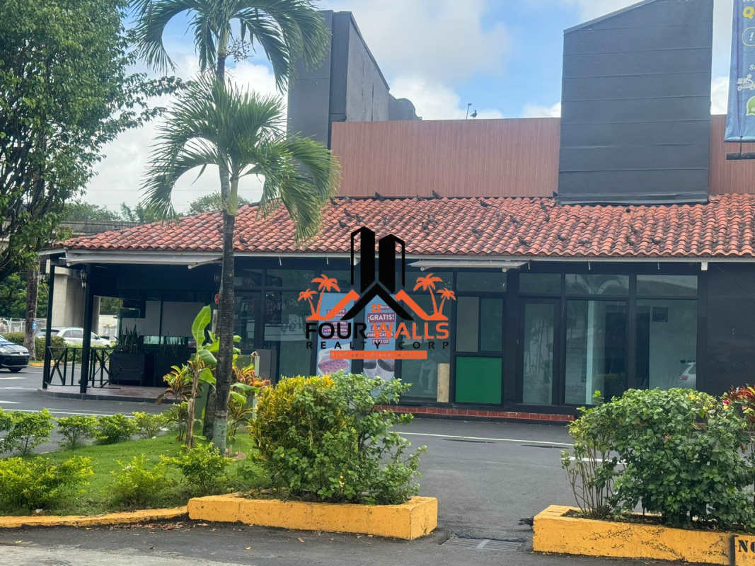 Terracotta roofed retail building with large windows and palm-shrub garden Albrook