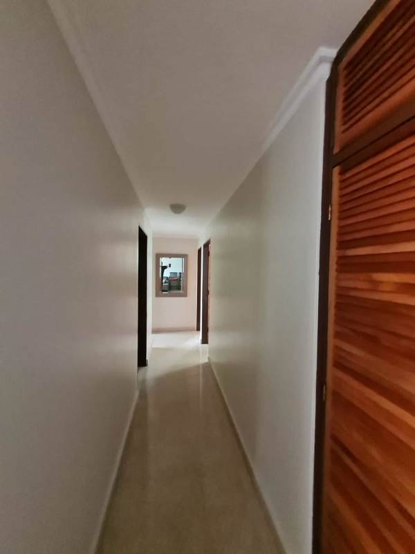 Long hallway inside PH Neptuno apartment with built-in wood closets and light floor
