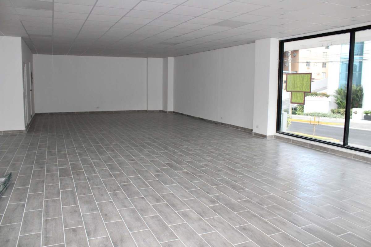 Bright commercial retail or office space with white walls, glass windows, and tiled floor
