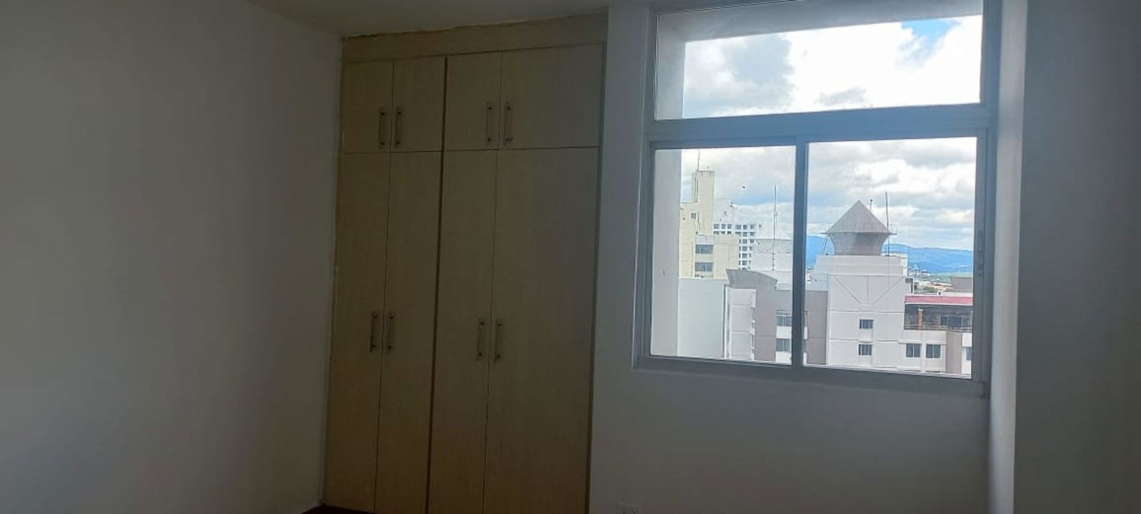 Modern kitchen with granite countertops, large window with Panama City view in Luxor Tower apartment