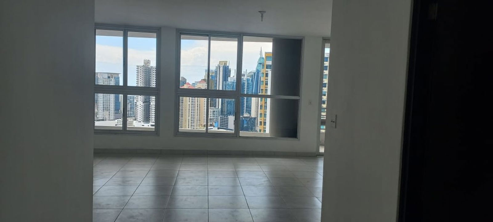 Bright bedroom with built-in closets and large windows offering city skyline views in PH Luxor Tower El Cangrejo