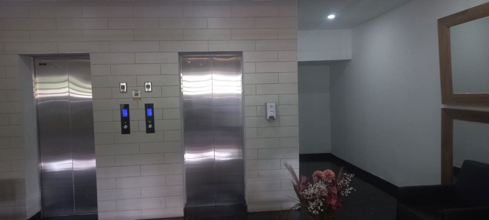 Elevator lobby with flower decor and stainless doors in PH Midtown Panama