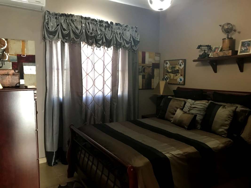 Stylish staircase with wrought iron railing in two-story house for sale Costa Sur Panama