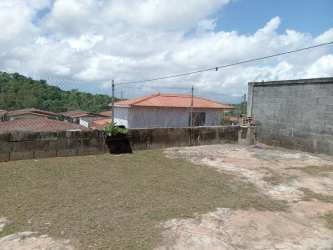 Concrete patio yard area with partial grass, fence, residential houses in Brisas del Golf Arraiján Panama