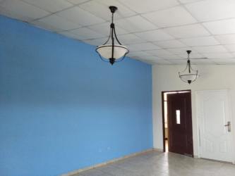 Modern living room with blue accent wall, two doors, ceiling lights in Panama rental home Brisas del Golf Arraiján