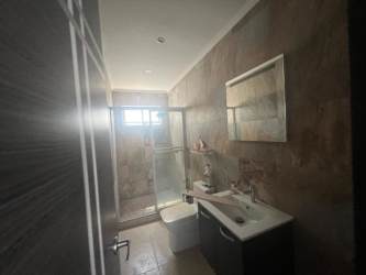 Bathroom with glass shower enclosure, vanity and tiled walls in Ibiza Beach Residence Panama
