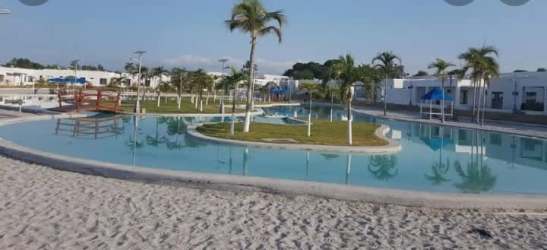 Artificial lagoon style pool with sandy beach palm island at Ibiza Beach Residence Coclé Panama