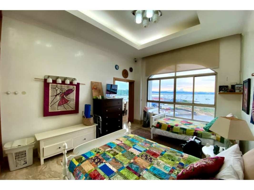 Bedroom with large window offering ocean views and colorful decor in PH Amador Heights Panama City
