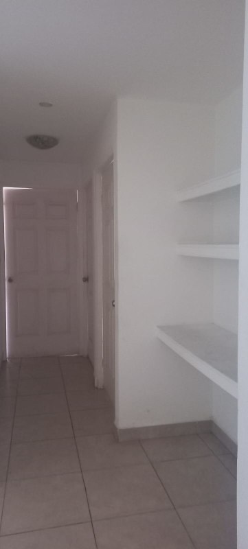 Apartment hallway featuring built-in shelves and tile floors in Carrasquilla Panama