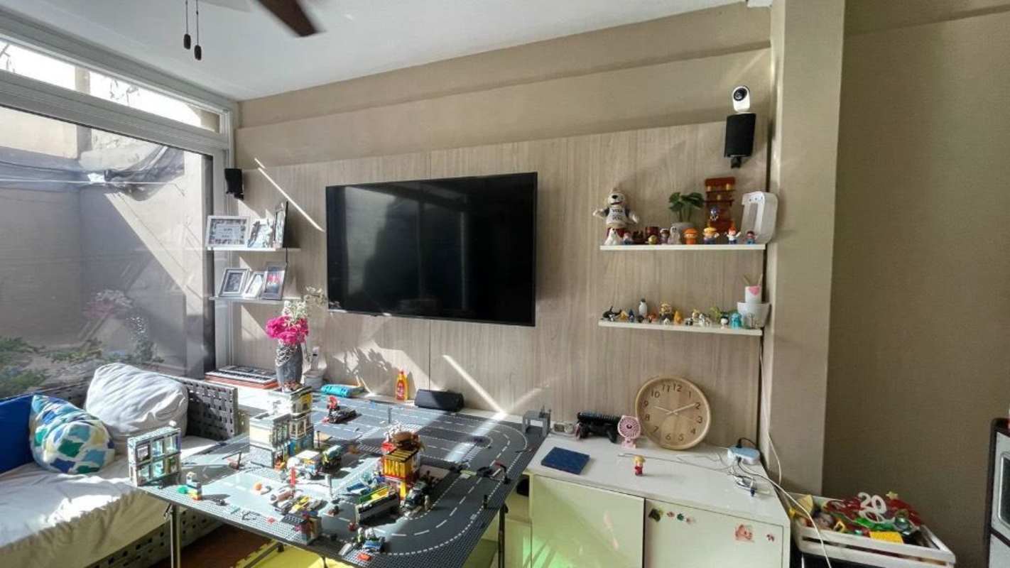 Family living room with wall TV, large window and children's toys in duplex home Condado del Rey Panama