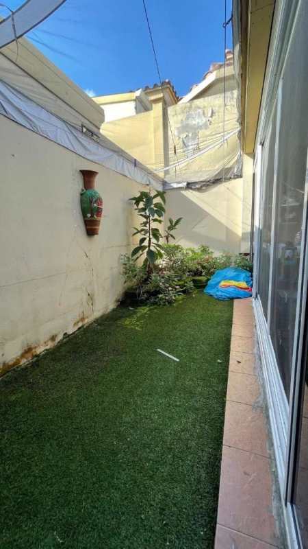 Narrow outdoor patio with artificial grass and plants in duplex house Condado del Rey Panama