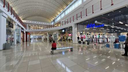 View of multiple retail outlets inside Westland Mall with large polished floor and advertising displays