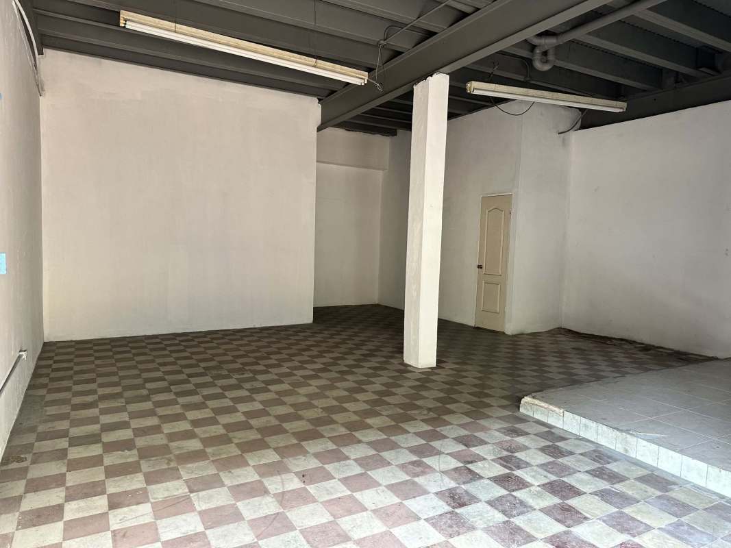 Empty commercial warehouse space with checkered floor and exposed rustic ceilings in Casco Viejo