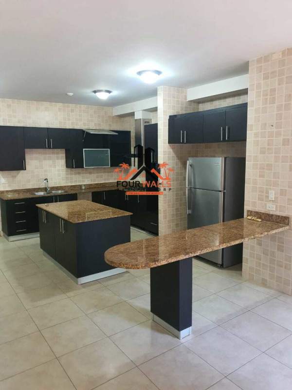 Sleek modern kitchen with granite counters and island at Amador Eights apartment Panama