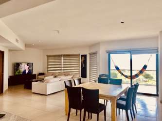 Contemporary dining room with large windows overlooking ocean in Olas 2 Panama