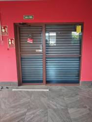 Commercial hallway with metal security shutter doors red walls Santiago Panama