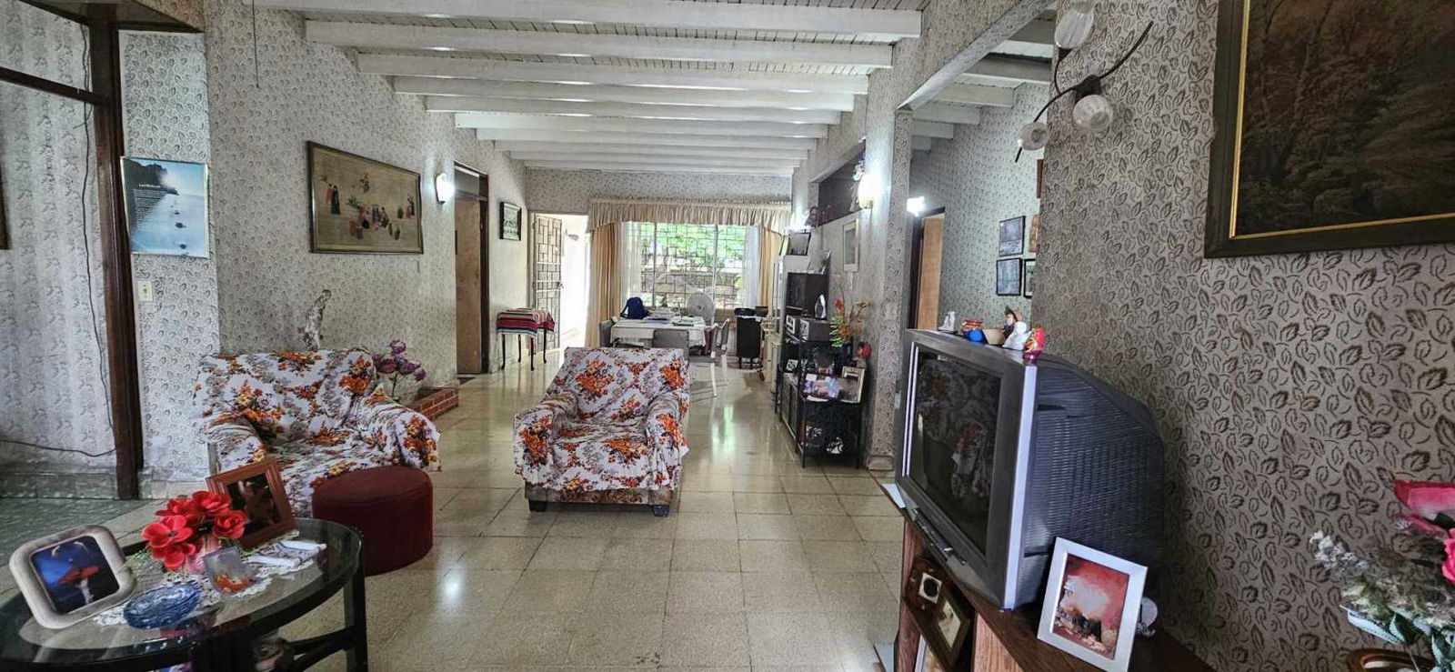 Vintage living and dining area with exposed beams floral sofa and large windows Carrasquilla Panama City