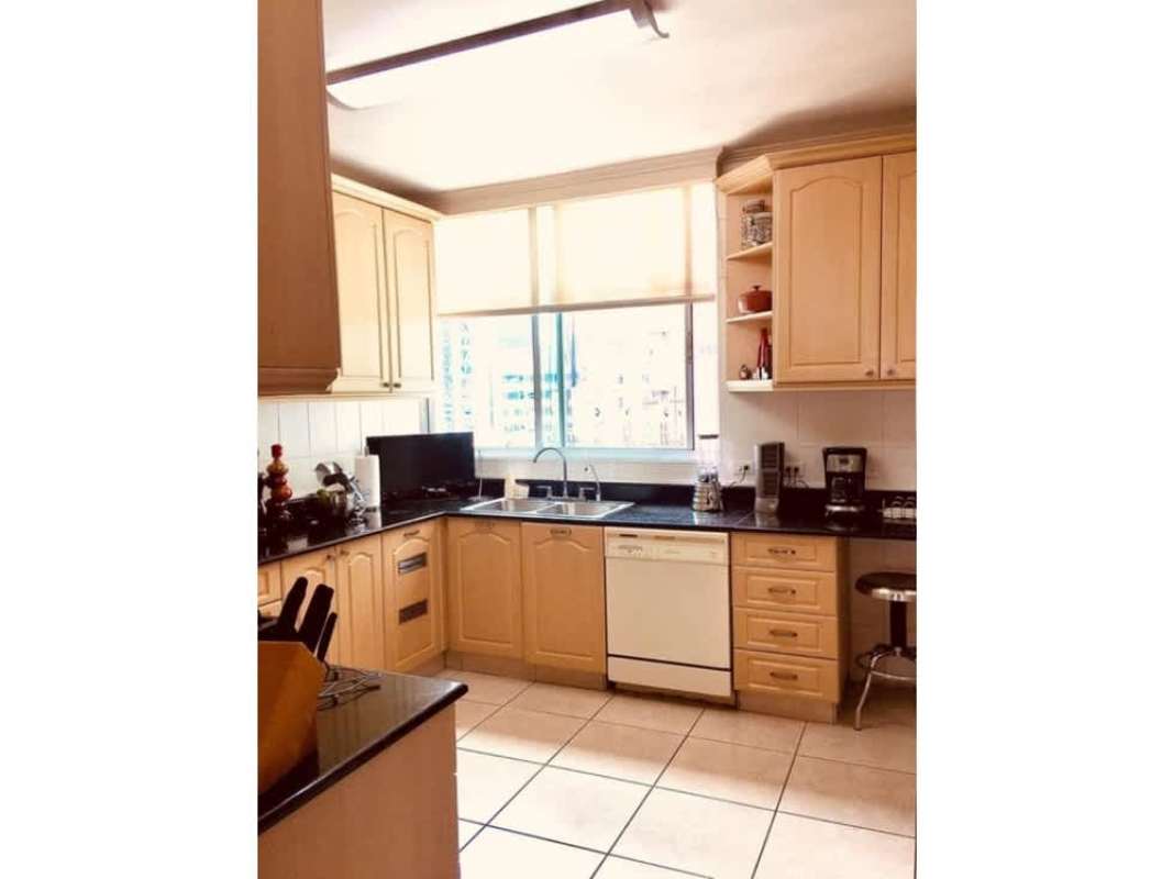 Traditional kitchen with granite counters and window at PH Bahía Esmeralda Marbella Panama City