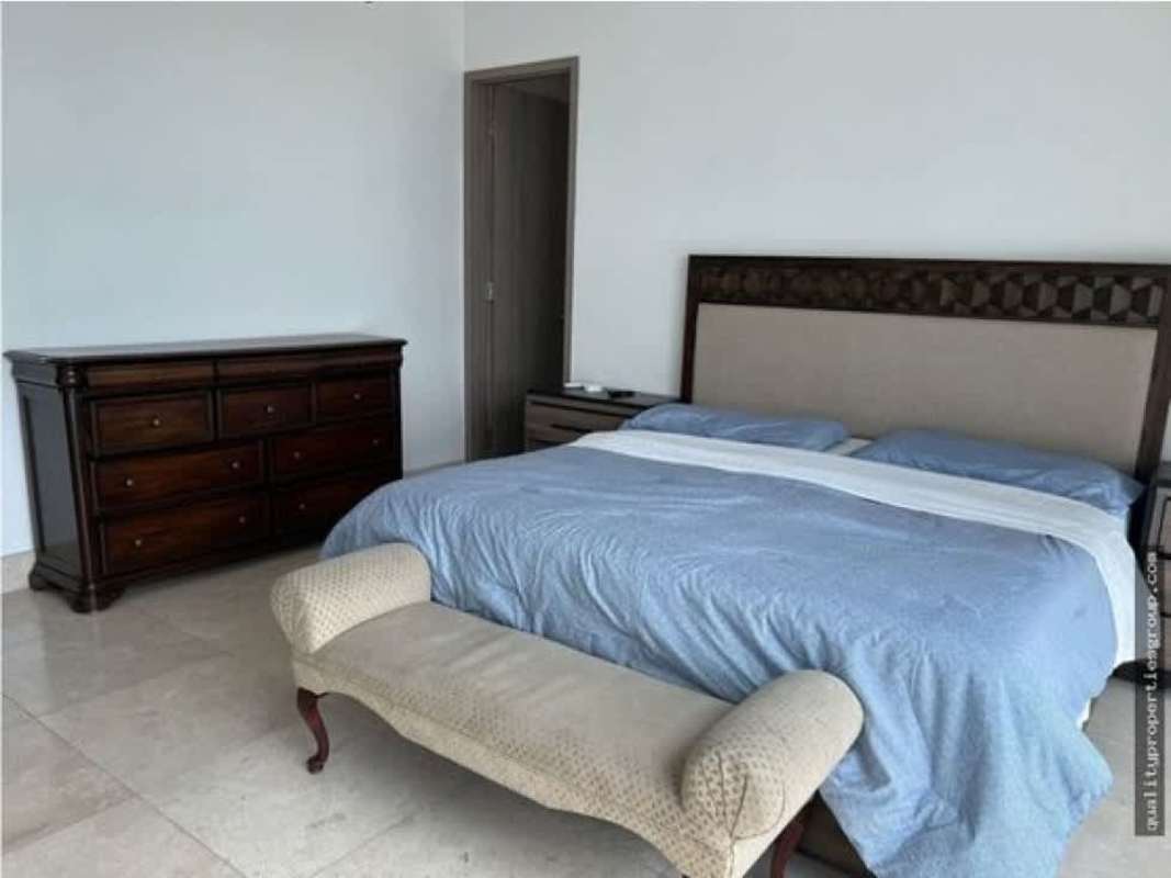 Master bedroom with king bed, classic furniture, and access to ensuite jacuzzi bathroom in Punta Paitilla