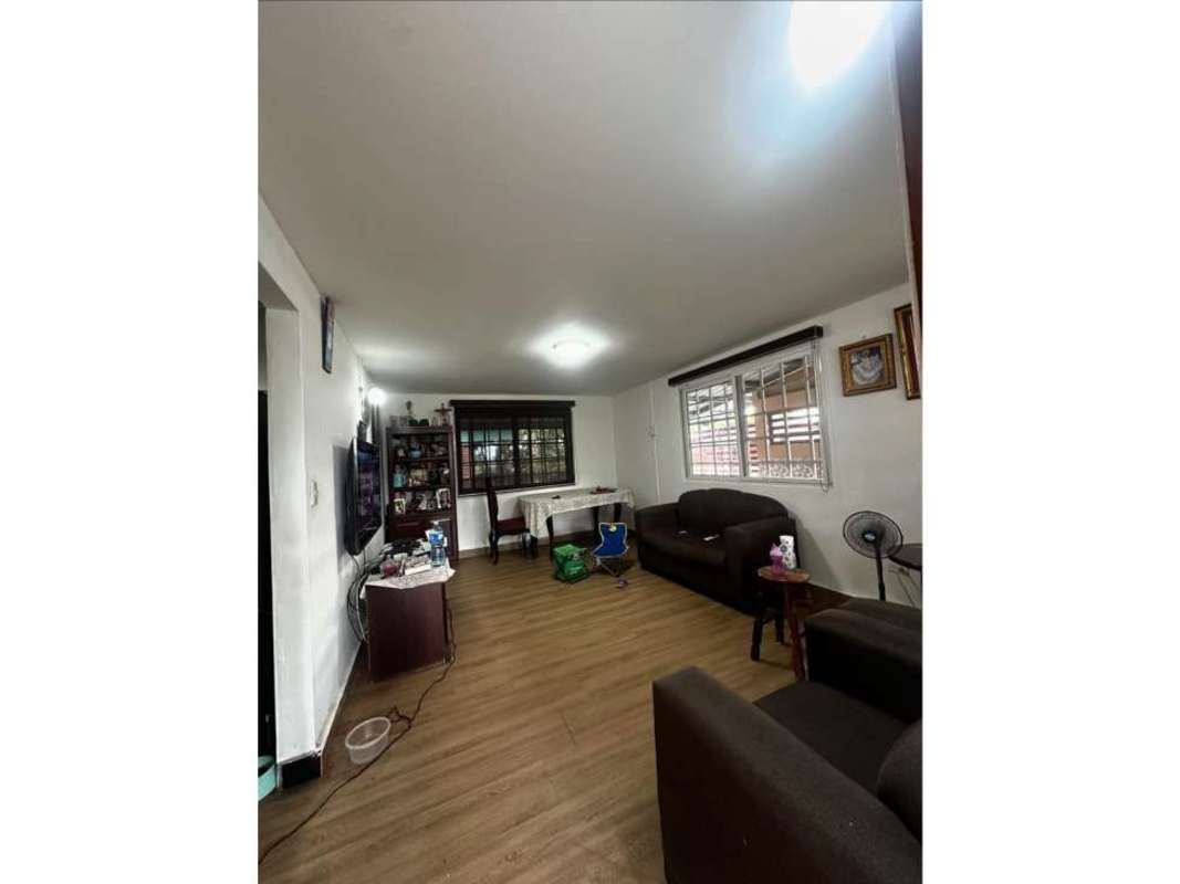 Living room with brown sofa and armchair, wood-look floor Ciudad Radial house Panama