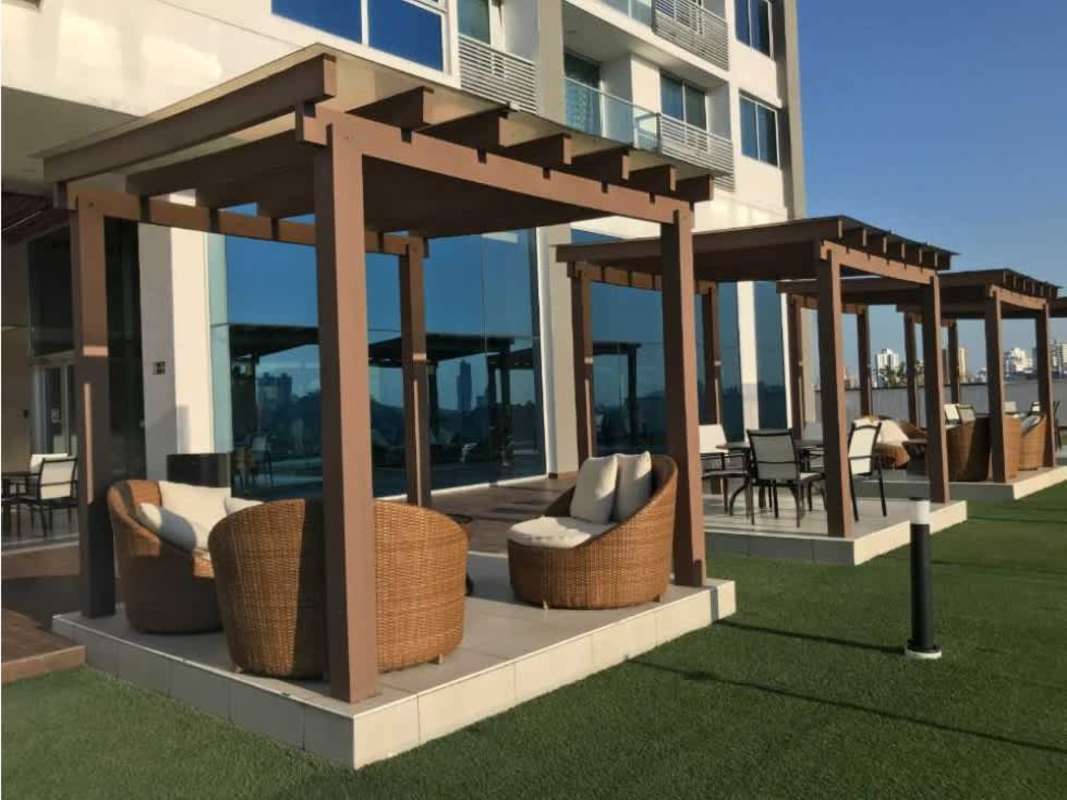 Outdoor lounge with pergolas, wicker chairs and skyline backdrop at PH Miraflores Panama
