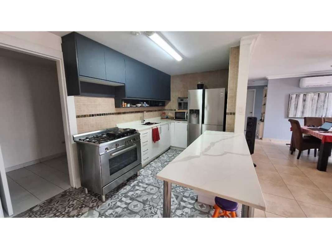 Kitchen with marble countertop, stainless appliances, dining space with red tablecloth Panama apartment