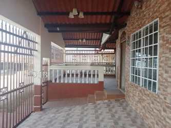 Covered front porch with iron gate and traditional brick at Quintas de Montelimar House La Chorrera