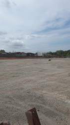 Large commercial lot along main avenue in Arraiján with clear skies and vegetation surrounding the plot
