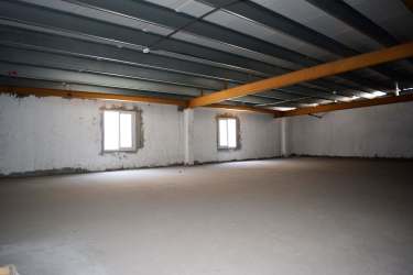 Unfinished commercial interior space with concrete floors and mezzanine capability at Azuero Center Chitré