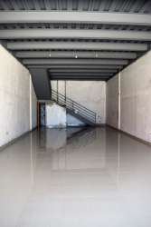 Warehouse style open floor with concrete finish and mezzanine at Azuero Center Chitré