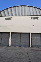 Exterior of warehouse with multiple roll-up doors and loading docks at Colón Free Zone Panama for commercial use