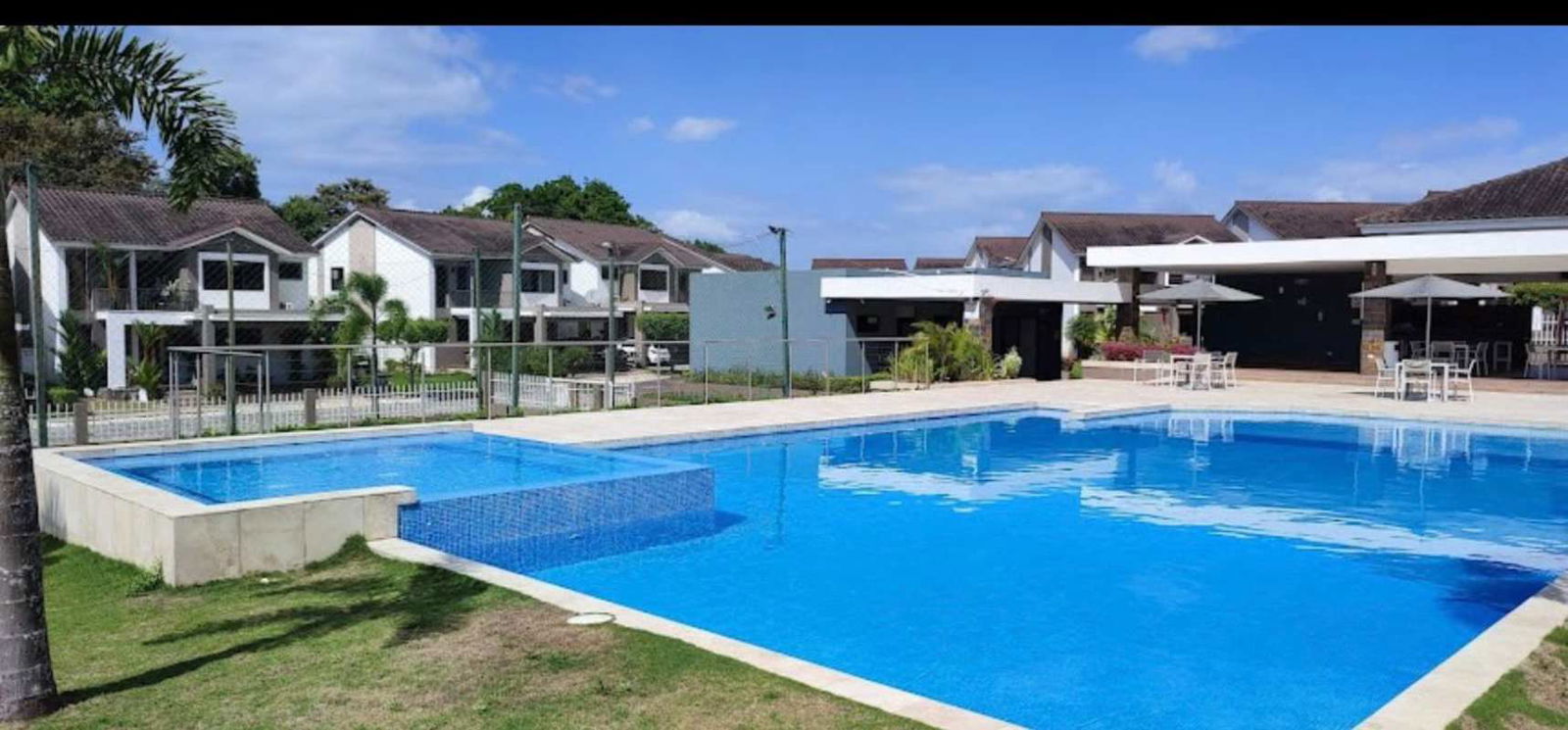 Modern communal pool surrounded by townhouses and landscaping in Brisas del Golf Panama