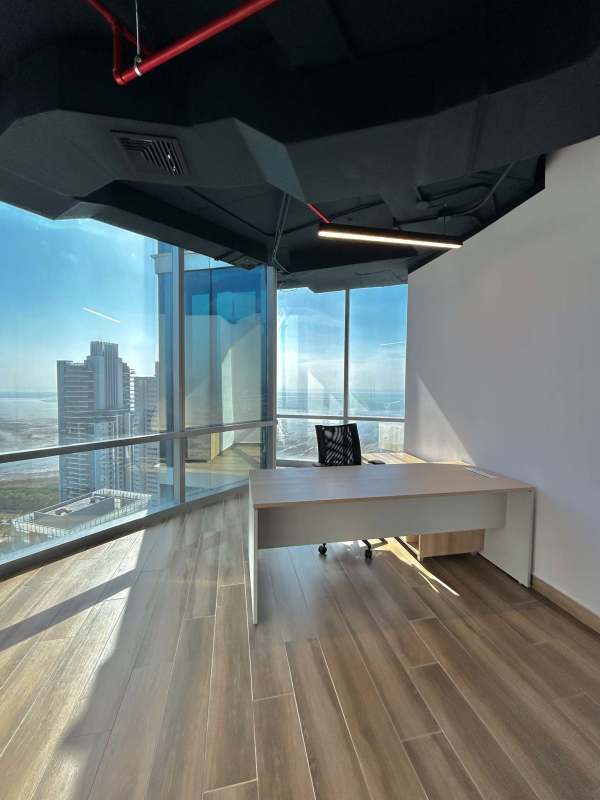 Open plan workspace with desks and natural light in Costa del Este business tower